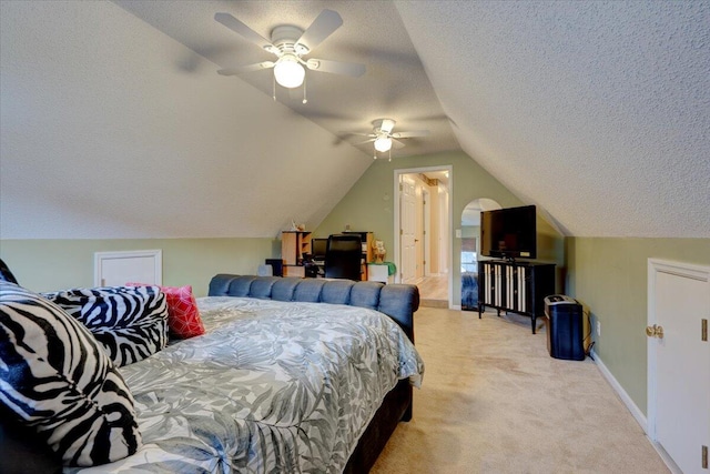 bedroom with a textured ceiling, light colored carpet, ceiling fan, and vaulted ceiling