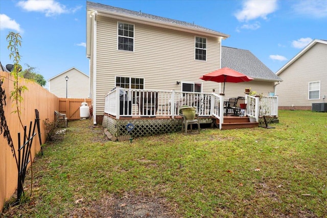 back of property featuring a lawn, a wooden deck, and central AC