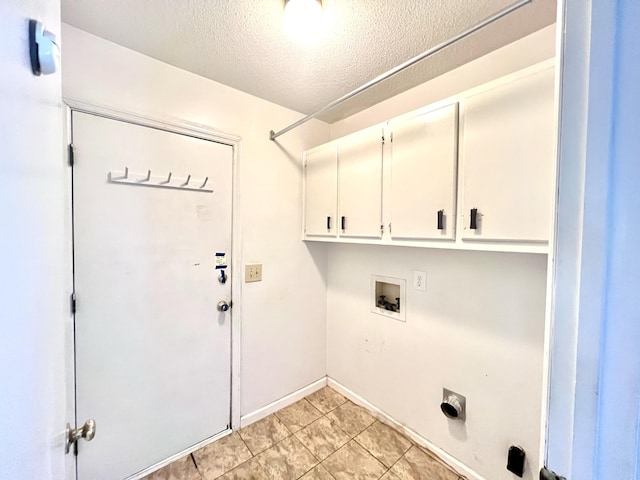 laundry area with baseboards, light tile patterned floors, a textured ceiling, washer hookup, and cabinet space