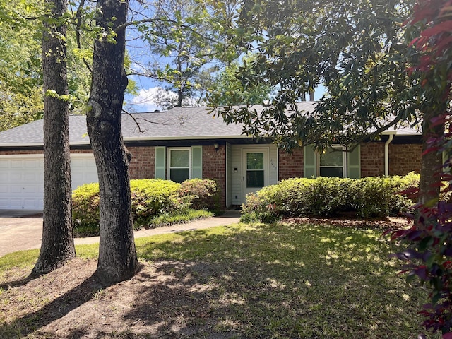 single story home with brick siding, a front yard, a shingled roof, and a garage