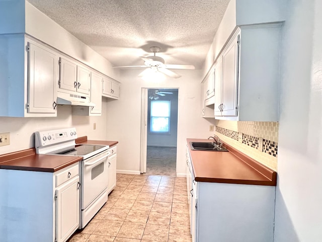 kitchen with a textured ceiling, a ceiling fan, under cabinet range hood, white electric range oven, and a sink