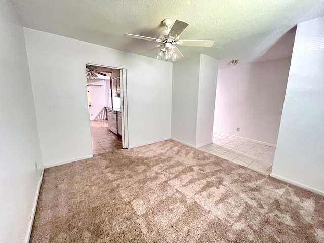tiled empty room featuring carpet, a textured ceiling, baseboards, and ceiling fan