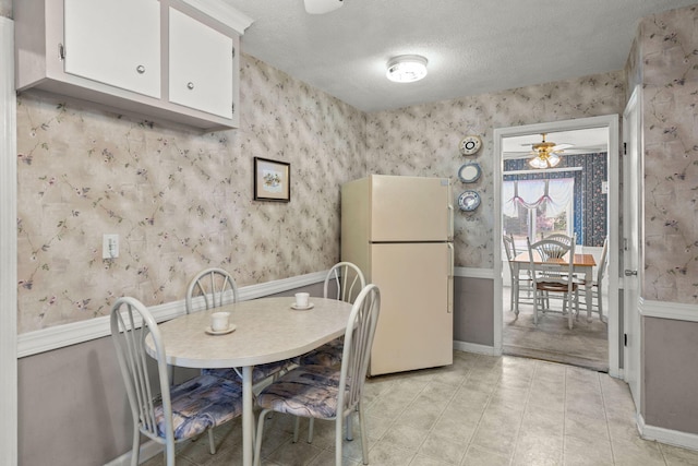 kitchen featuring ceiling fan, white cabinets, a textured ceiling, and white refrigerator