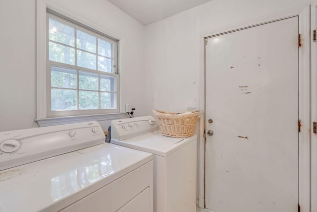 laundry area with washing machine and dryer and a textured ceiling