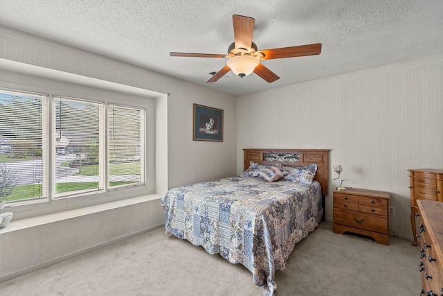 bedroom with ceiling fan, carpet floors, and a textured ceiling