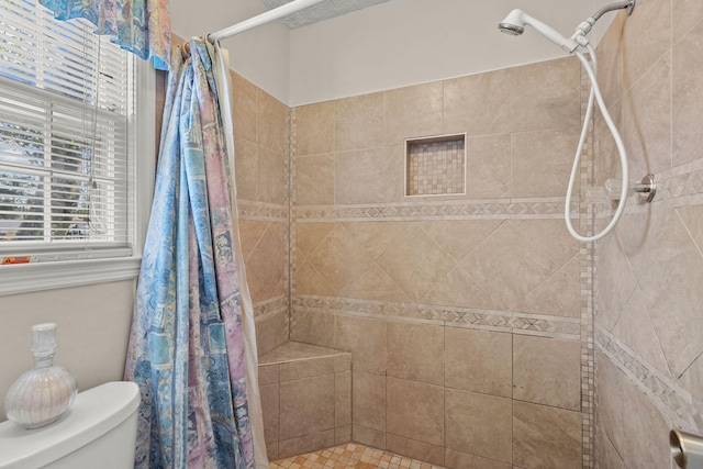 bathroom with curtained shower and toilet