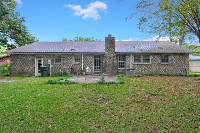 rear view of property with central AC unit, a patio area, and a yard