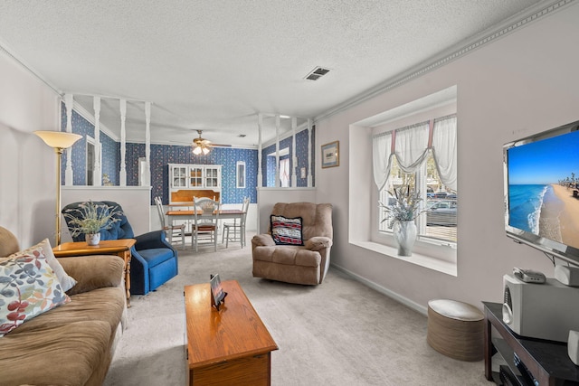 carpeted living room with ceiling fan, crown molding, and a textured ceiling