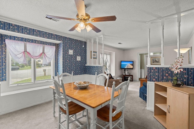 dining room featuring ceiling fan, crown molding, carpet floors, and a textured ceiling