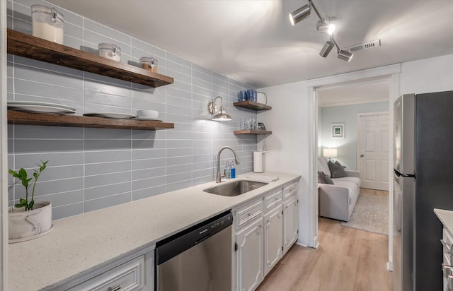 kitchen featuring open shelves, stainless steel appliances, backsplash, white cabinets, and a sink