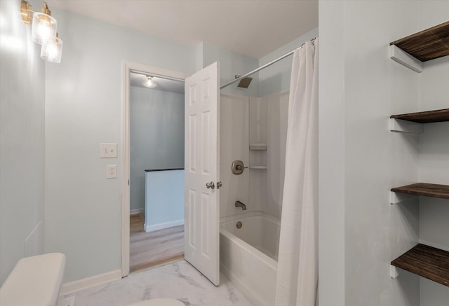 full bathroom with toilet, marble finish floor, baseboards, and shower / bath combo with shower curtain