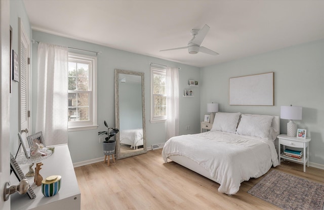 bedroom featuring visible vents, light wood finished floors, a ceiling fan, and baseboards