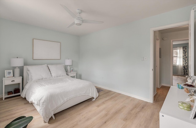 bedroom with baseboards, a ceiling fan, and light wood-style floors