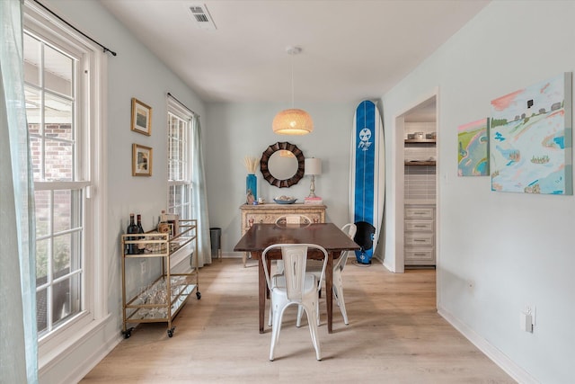 dining area featuring light wood-type flooring, visible vents, and baseboards