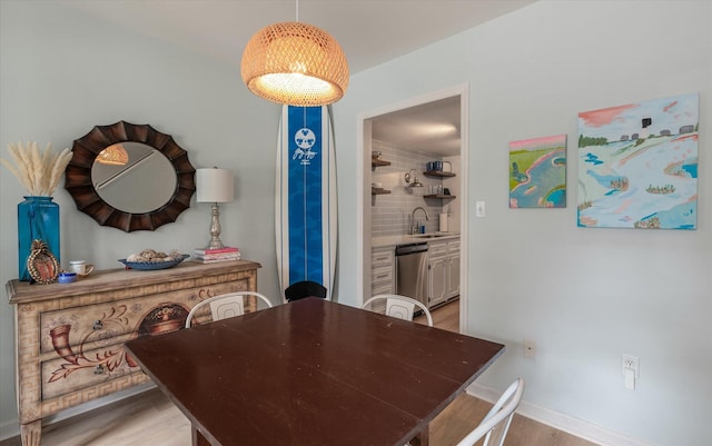 dining room featuring light wood-type flooring and baseboards