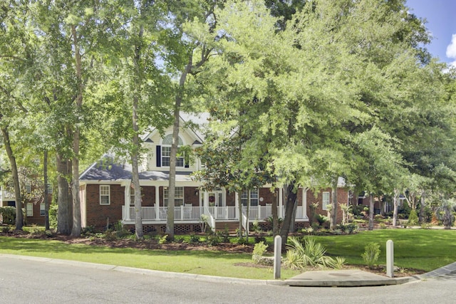 obstructed view of property featuring brick siding, a porch, and a front lawn