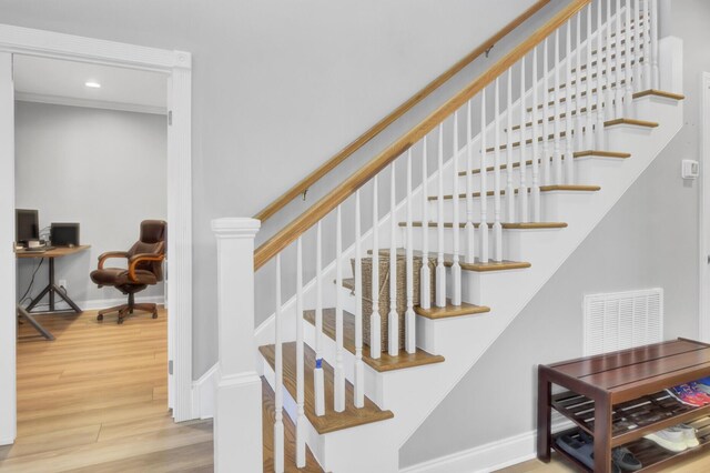 staircase with wood finished floors, baseboards, and recessed lighting