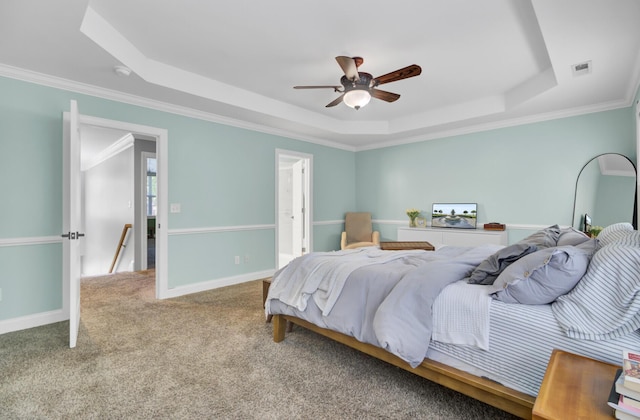 bedroom with a raised ceiling, ornamental molding, carpet floors, baseboards, and ceiling fan