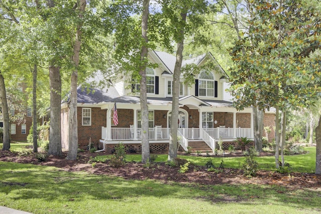 view of front facade featuring covered porch, a front lawn, and brick siding