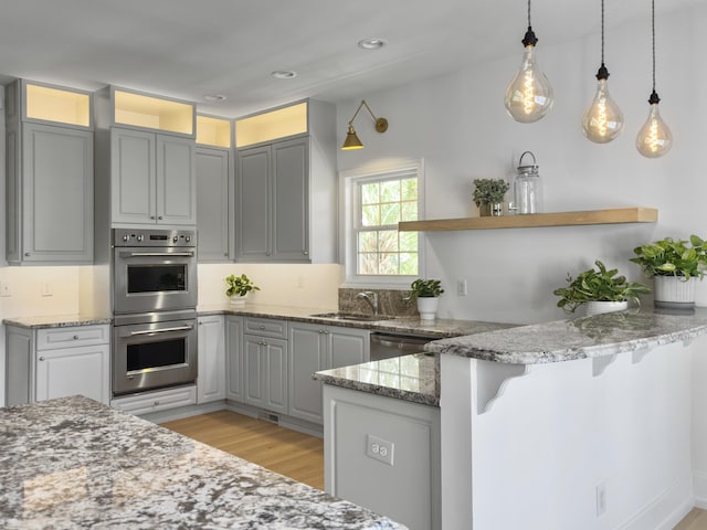 1491 Greenshade Way, Mount Pleasant, SC 29464 - kitchen with double oven, open shelves, a peninsula, a sink, and light stone counters