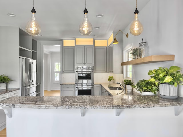 1491 Greenshade Way, Mount Pleasant, SC 29464 - kitchen featuring appliances with stainless steel finishes, open shelves, a sink, gray cabinets, and light stone countertops