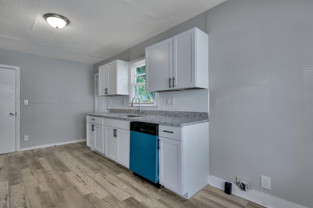 kitchen featuring stainless steel dishwasher, white cabinetry, sink, and light hardwood / wood-style flooring