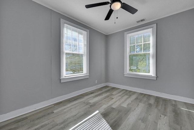 unfurnished room featuring ceiling fan, a healthy amount of sunlight, light wood-type flooring, and ornamental molding