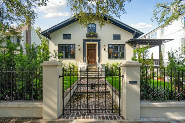 view of front of property featuring a fenced front yard, a gate, and stucco siding