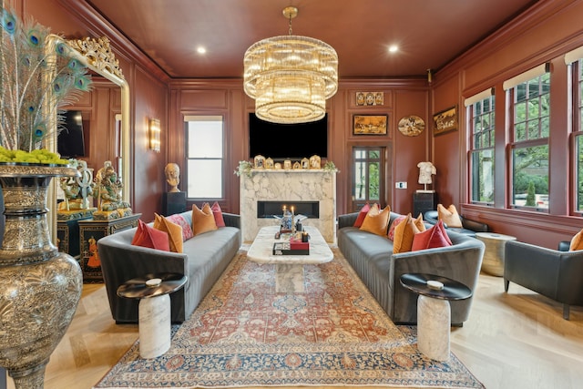 living area featuring a fireplace, crown molding, recessed lighting, a decorative wall, and an inviting chandelier