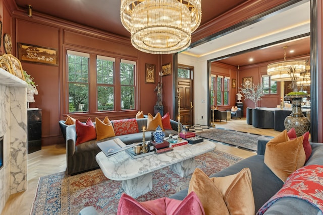 living area featuring an inviting chandelier, crown molding, and a high end fireplace