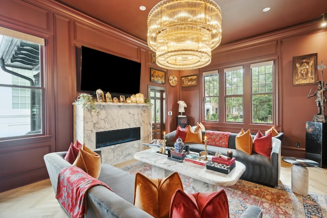 living room with ornamental molding, recessed lighting, a high end fireplace, and an inviting chandelier