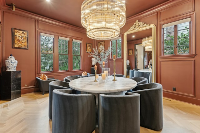 dining room featuring ornamental molding, a notable chandelier, and a decorative wall