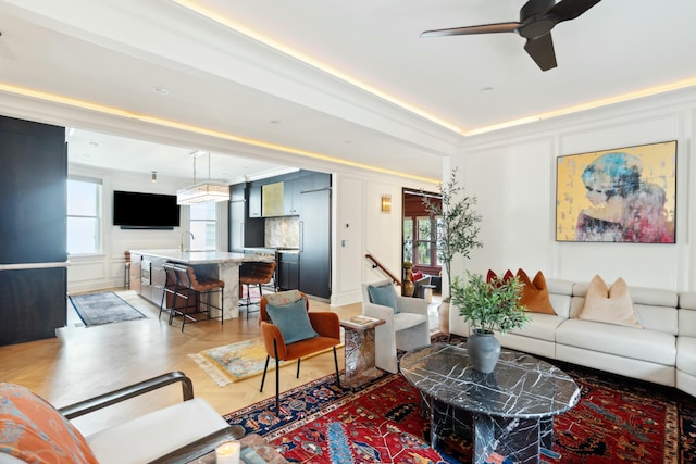 living room with ceiling fan and a decorative wall