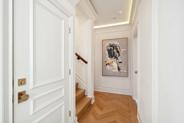 corridor featuring a decorative wall and stairs