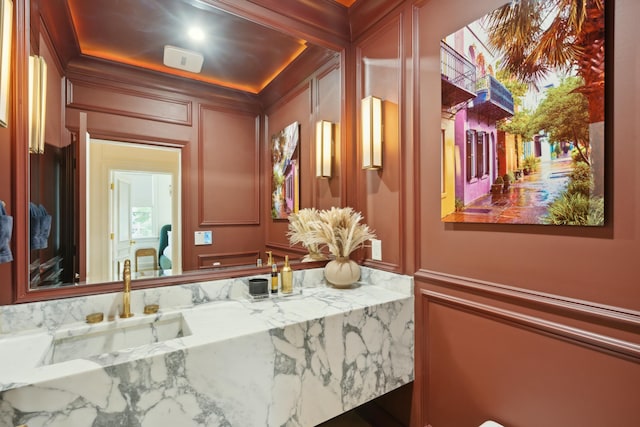 bathroom with vanity and a decorative wall