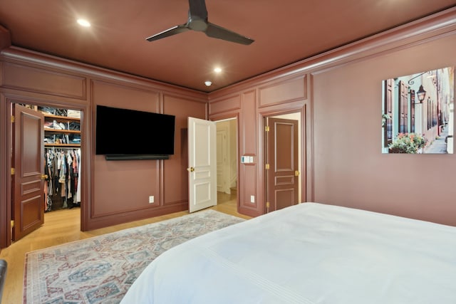 bedroom with ornamental molding, a closet, a decorative wall, and a spacious closet