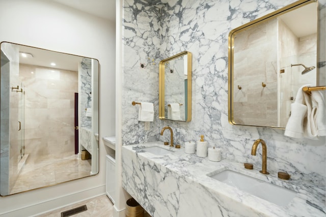 full bath featuring double vanity, a sink, visible vents, and a shower stall