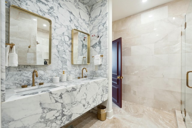 bathroom featuring double vanity, a stall shower, a sink, and tile walls