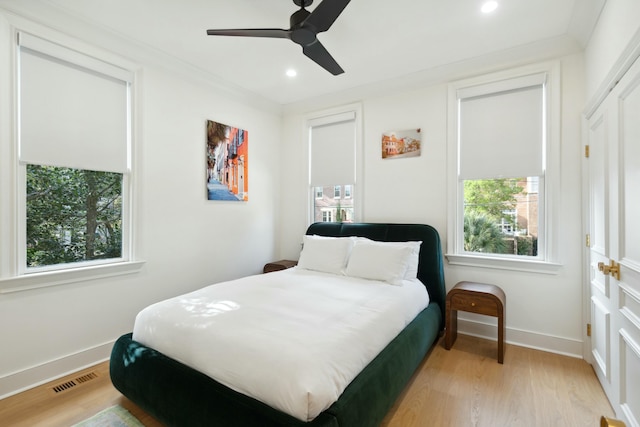 bedroom with light wood-type flooring, multiple windows, and visible vents