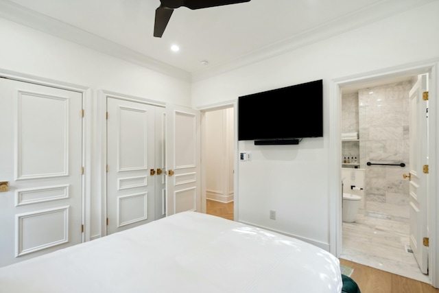 bedroom with connected bathroom, recessed lighting, wood finished floors, multiple closets, and ornamental molding