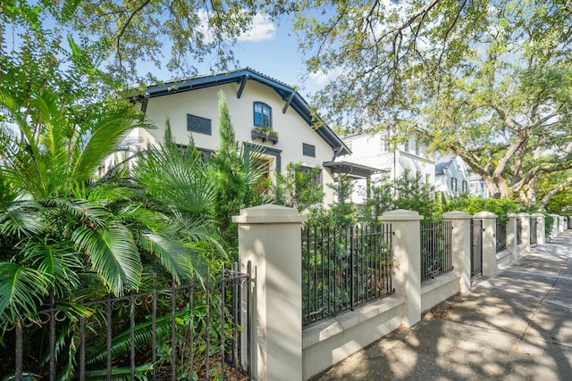 view of front of house with a fenced front yard, a gate, and stucco siding