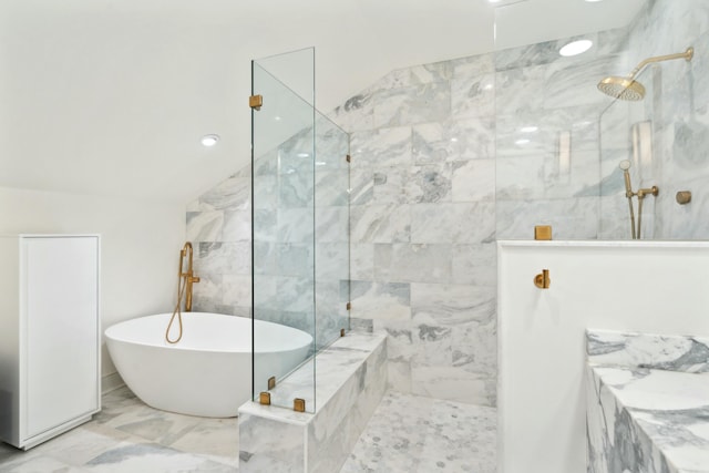 bathroom featuring marble finish floor, vaulted ceiling, a walk in shower, and a freestanding bath