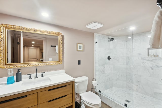 full bath with toilet, a marble finish shower, and vanity