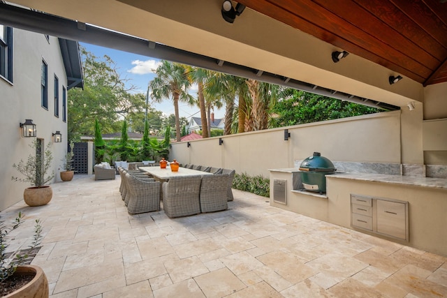 view of patio with grilling area, outdoor dining area, area for grilling, and fence