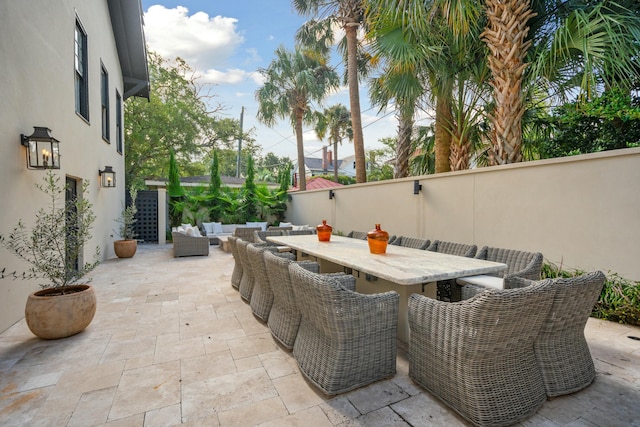 view of patio featuring outdoor dining space, fence, and an outdoor living space