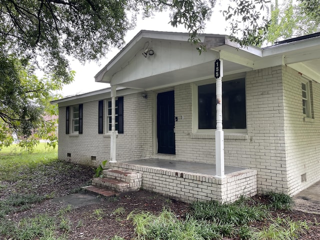 view of front of property with brick siding and crawl space