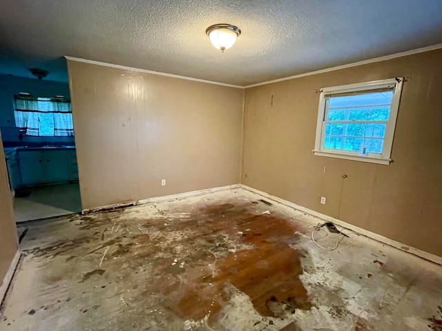 empty room with crown molding and a textured ceiling