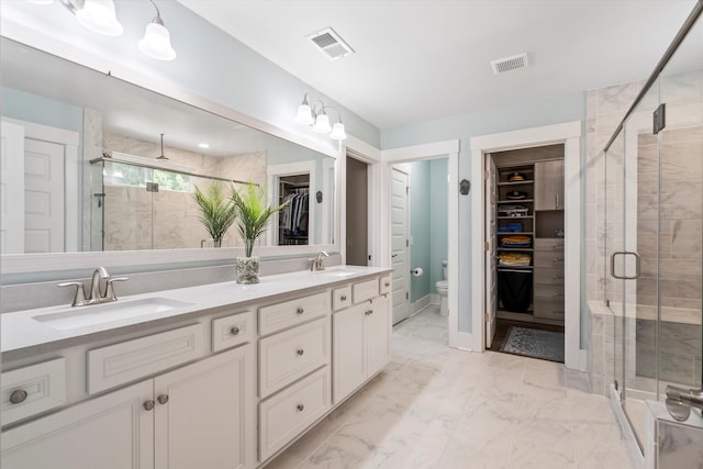 2331 Brinkley Rd, Johns Island, SC 29455 - bathroom featuring a walk in closet, double vanity, a shower stall, and marble finish floors