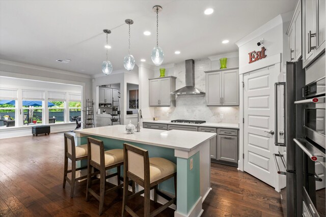 2331 Brinkley Rd, Johns Island, SC 29455 - kitchen with wall chimney range hood, gray cabinets, decorative backsplash, recessed lighting, and an island with sink