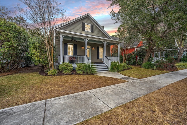 bungalow-style house with a lawn and a porch